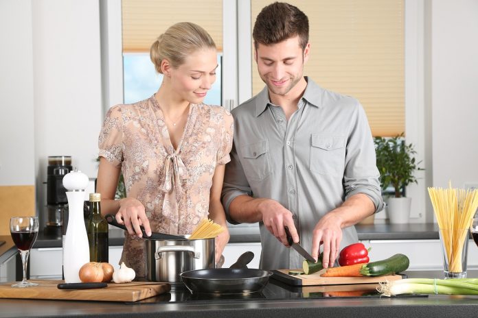 Kobieta i mężczyzna przygotowują posiłek w apartamencie, zdjęcie ilustracyjne