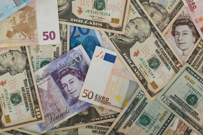 banknoty dolary funty i euro na stole